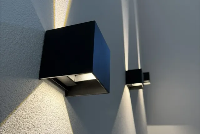 Wandleuchte mit Lichtkegeln an einer Wand
